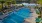 a swimming pool with trees and a building in the background